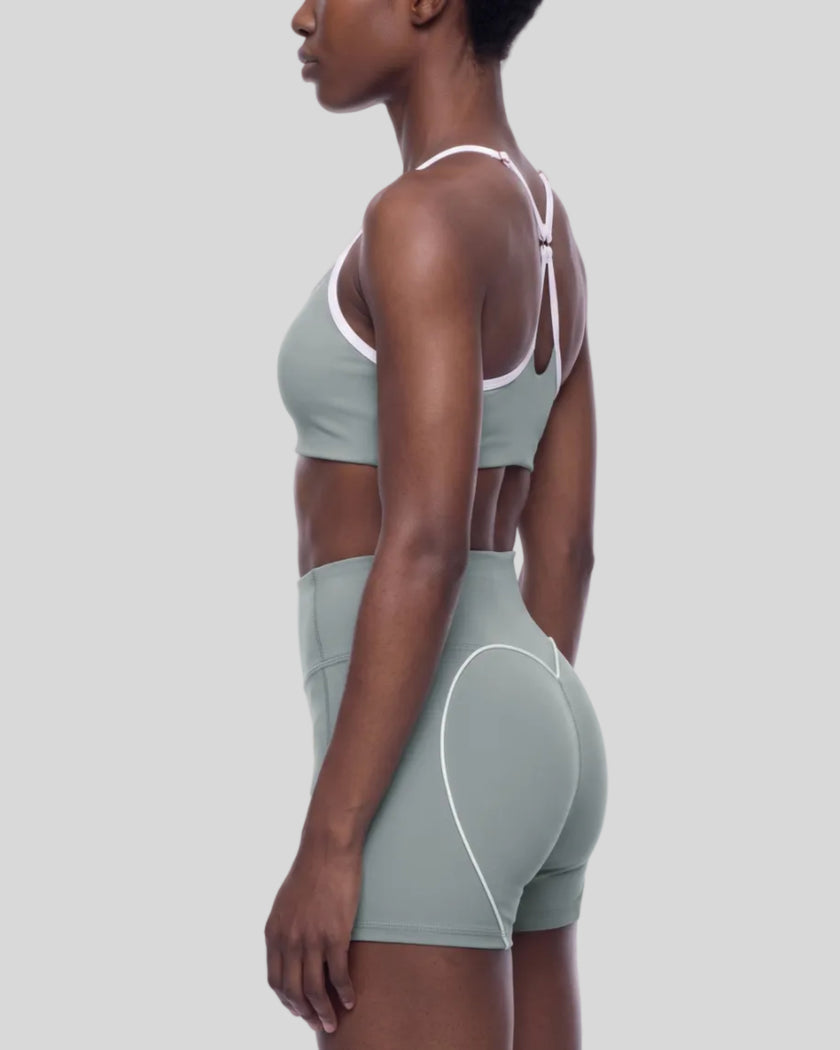 Mid body side view of woman wearing fitted haze blue TrackLine Sculpt Sports Bra
