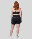 Full body back view of woman wearing black TrackLine Sculpt Sports Bra and matching TrackLine Sculpt Shorts