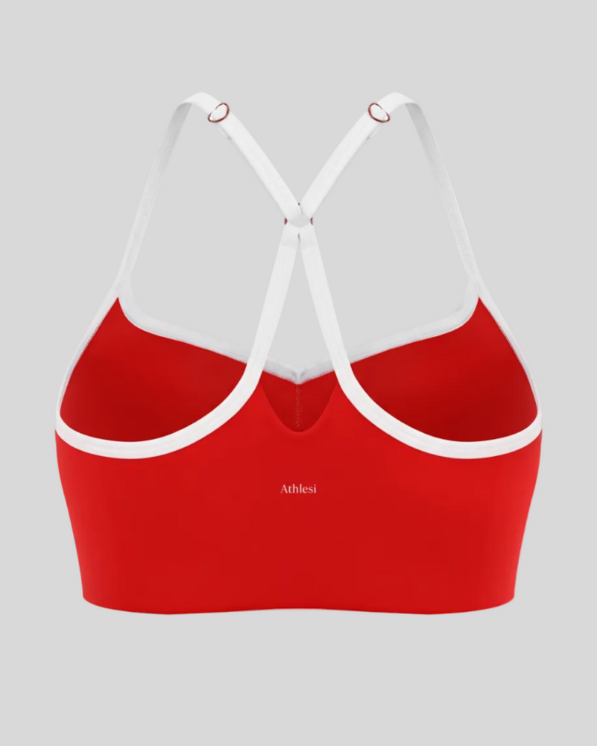 Back view of red TrackLine Sculpt Sports Bra featuring white crossover straps and open-back design