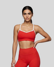 Upper body front view of woman wearing red TrackLine Sculpt Sports Bra with white contrast trim