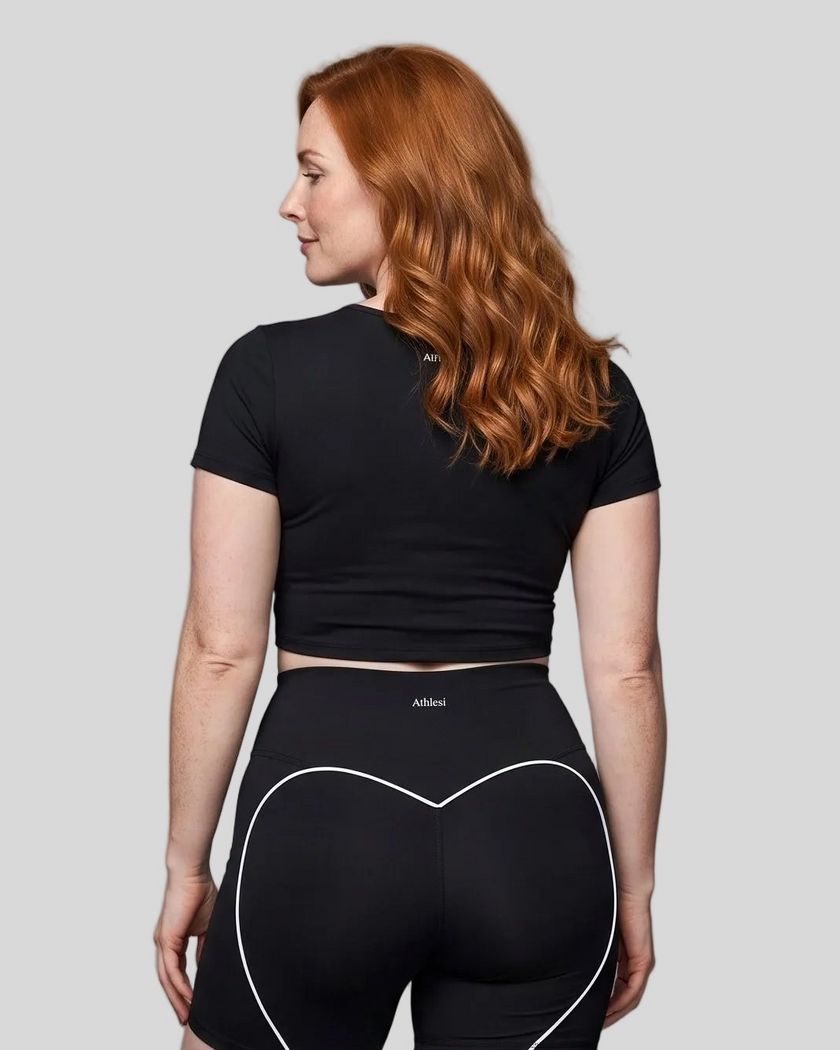 Upper body back view of woman wearing black TrackLine Sculpt Tee with subtle back logo