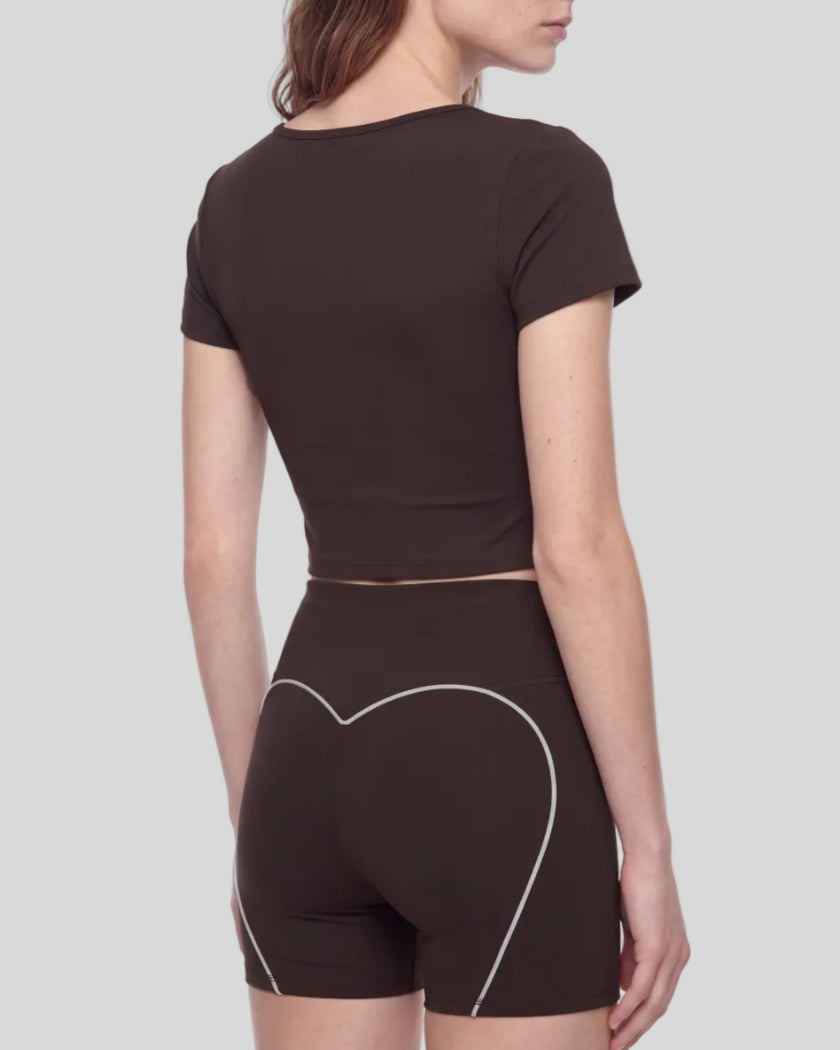 Angled back view of woman wearing brown TrackLine Sculpt Tee with cropped silhouette