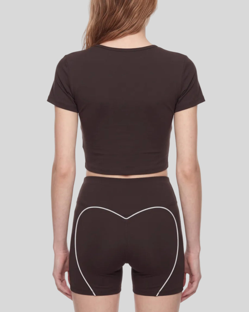 Mid body back view of woman wearing brown TrackLine Sculpt Tee with subtle back logo