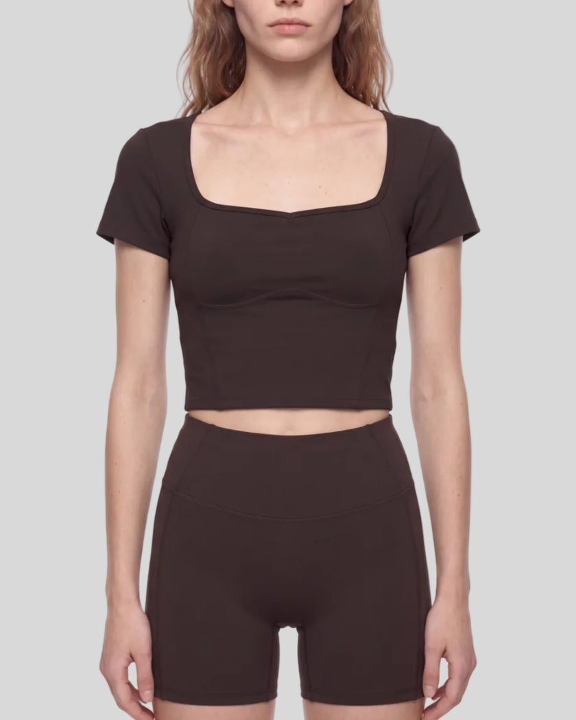 Mid body front view of woman wearing brown TrackLine Sculpt Tee with sculpted neckline
