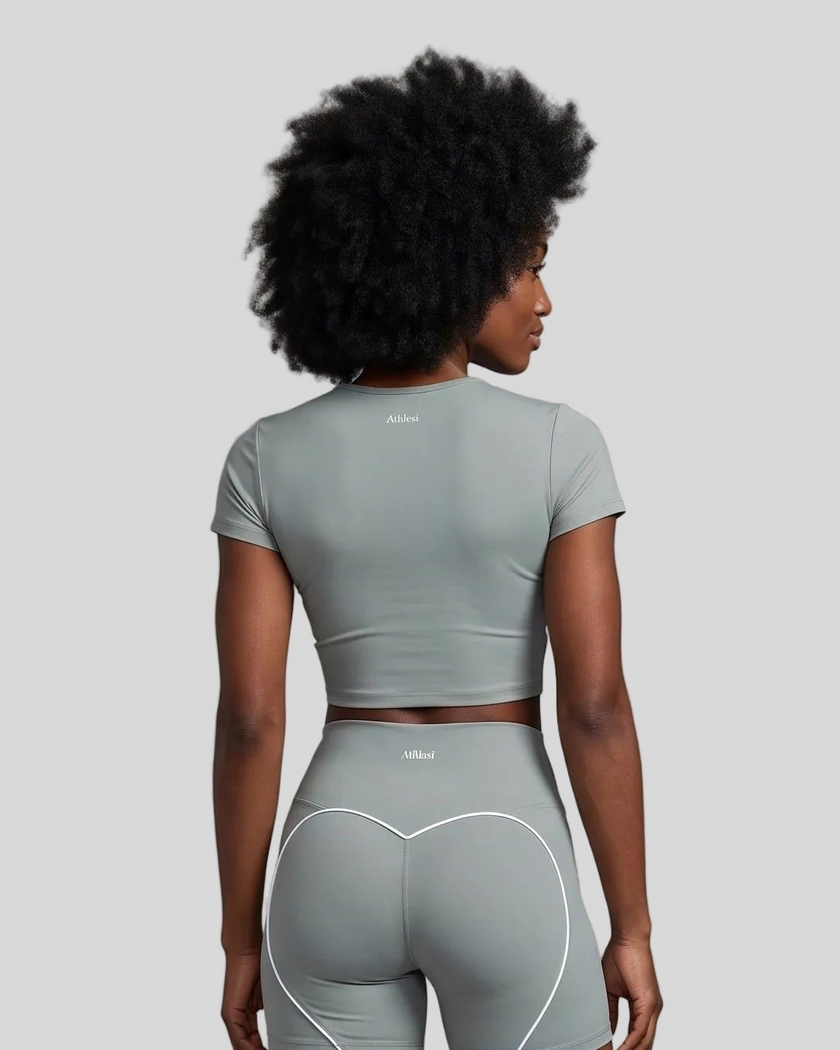 Upper body back view of woman wearing haze blue TrackLine Sculpt Tee with subtle back logo