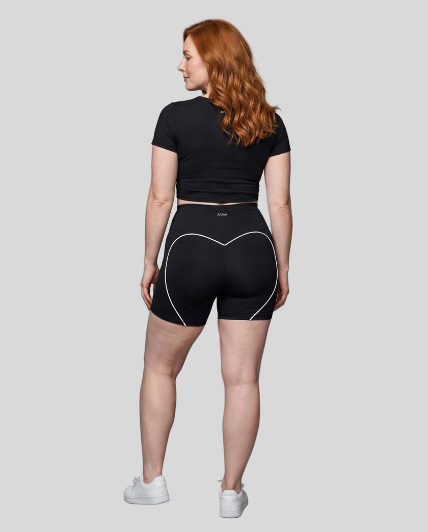Full body back view of woman wearing black TrackLine Sculpt Tee with coordinating activewear shorts