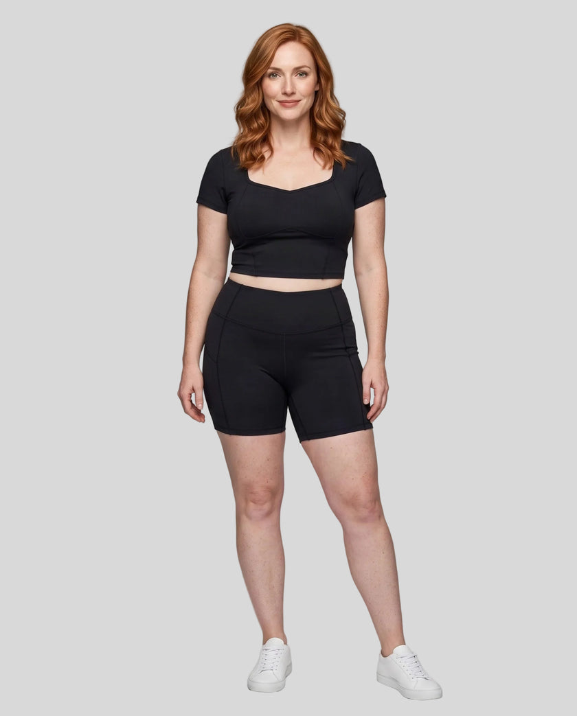 Full body front view of woman wearing black TrackLine Sculpt Tee styled with matching activewear shorts