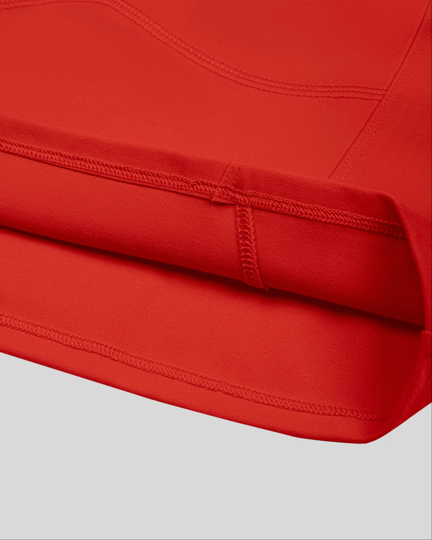 Closeup of cropped straight hem and fitted waist on red TrackLine Sculpt Tee