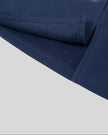 Hem and side slit detail closeup of the Athlesi TrackLine Slit Skirt in blue