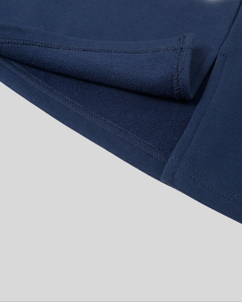 Hem and side slit detail closeup of the Athlesi TrackLine Slit Skirt in blue