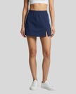 Lower body front view of a woman wearing the Athlesi TrackLine Slit Skirt in blue