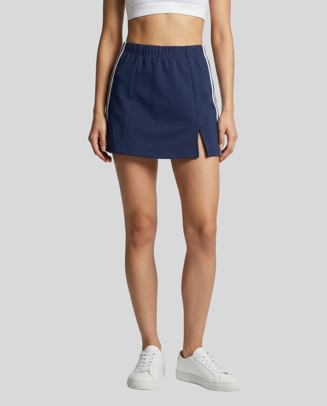 Lower body front view of a woman wearing the Athlesi TrackLine Slit Skirt in blue
