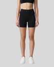 Model wearing the TrackLine Sprint Shorts in black with pink and white side stripes front view
