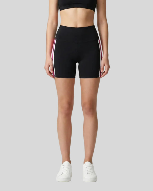 Model wearing the TrackLine Sprint Shorts in black with pink and white side stripes front view