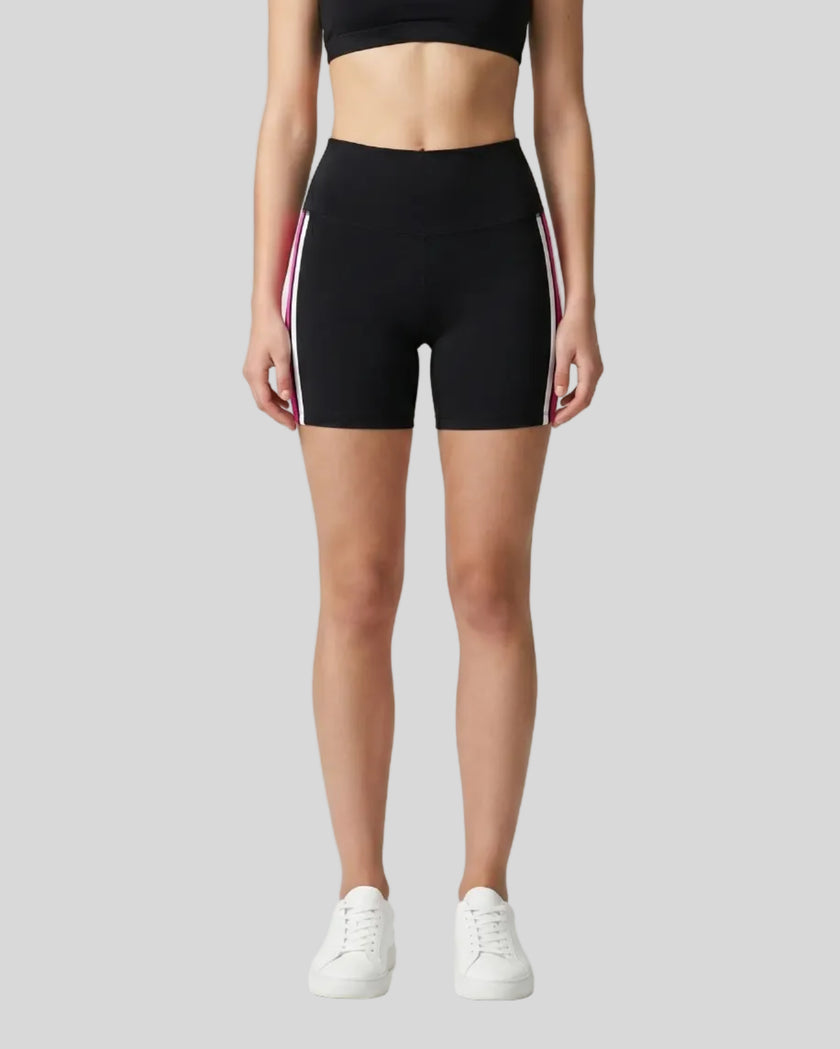 Model wearing the TrackLine Sprint Shorts in black with pink and white side stripes front view