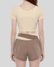 Woman wearing TrackLine Synergy Cropped Tee in Apricot with Khaki panel, mid body back view