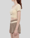 Woman wearing TrackLine Synergy Cropped Tee in Apricot with Khaki panel, mid body side view