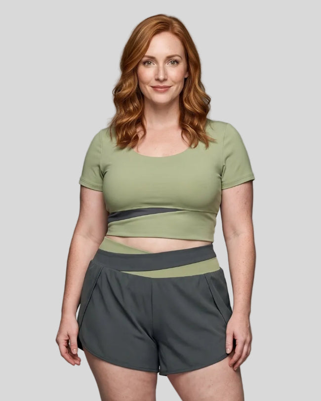 Woman wearing TrackLine Synergy Cropped Tee in Bean Green with Dark Gray panel, front view