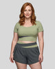 Woman wearing TrackLine Synergy Cropped Tee in Bean Green with Dark Gray panel, front view