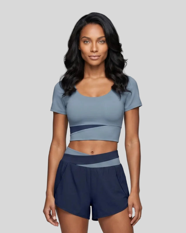 Woman wearing TrackLine Synergy Cropped Tee in Gray Blue with Navy Blue panel, front view