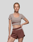 Woman wearing TrackLine Synergy Cropped Tee in Gray Purple with Brick Red panel, front view