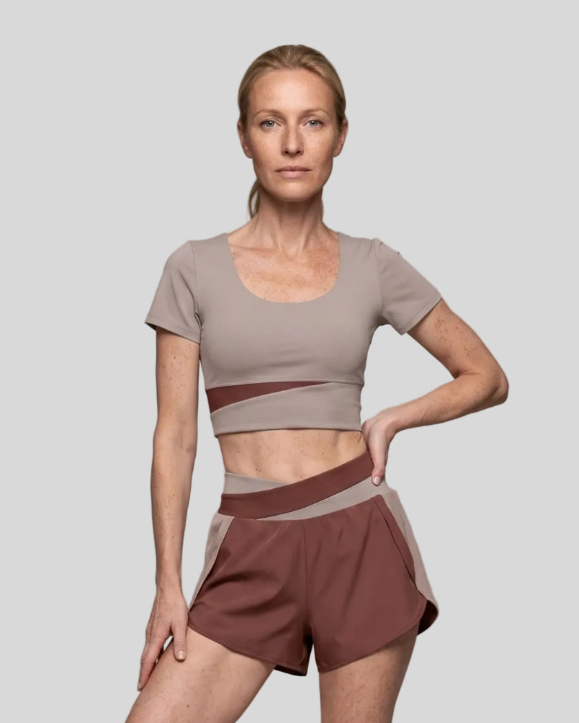 Woman wearing TrackLine Synergy Cropped Tee in Gray Purple with Brick Red panel, front view