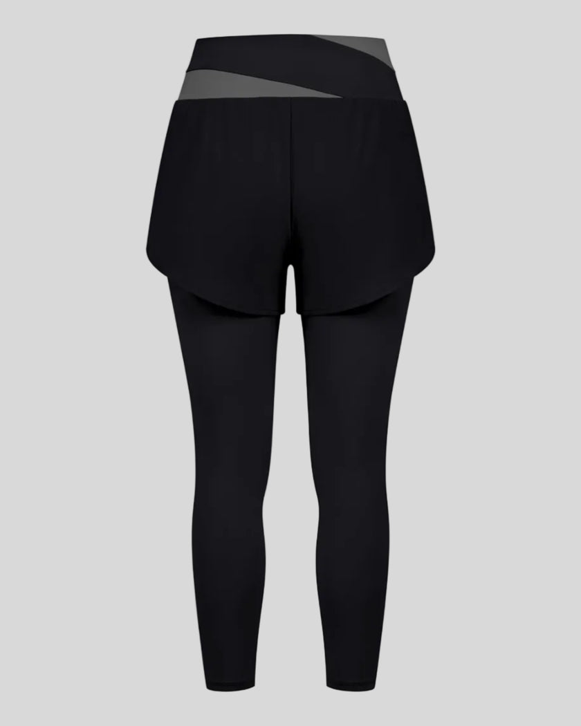TrackLine Synergy Layered Leggings in black with dark gray crossover waistband and overlay shorts back view