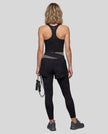 Full body back view of woman wearing TrackLine Synergy Layered Leggings in black and dark gray