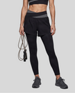 Lower body front view of woman wearing TrackLine Synergy Layered Leggings in black with dark gray crossover waistband