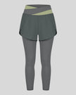 TrackLine Synergy Layered Leggings in dark gray with bean green crossover waistband and overlay shorts front view