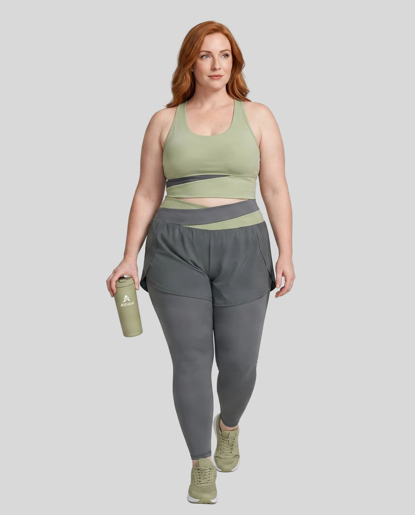 Full body front view of woman wearing TrackLine Synergy Layered Leggings in dark gray and bean green