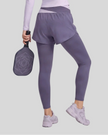 Lower body back view of woman wearing TrackLine Synergy Layered Leggings in deep purple with light purple crossover waistband