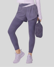 Lower body front view of woman wearing TrackLine Synergy Layered Leggings in deep purple with light purple crossover waistband