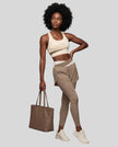 Full body front view of woman wearing TrackLine Synergy Layered Leggings in light coffee and apricot