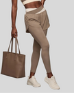 Lower body front view of woman wearing TrackLine Synergy Layered Leggings in light coffee with apricot crossover waistband