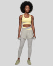 Full body front view of woman wearing TrackLine Synergy Layered Leggings in light gray and light yellow