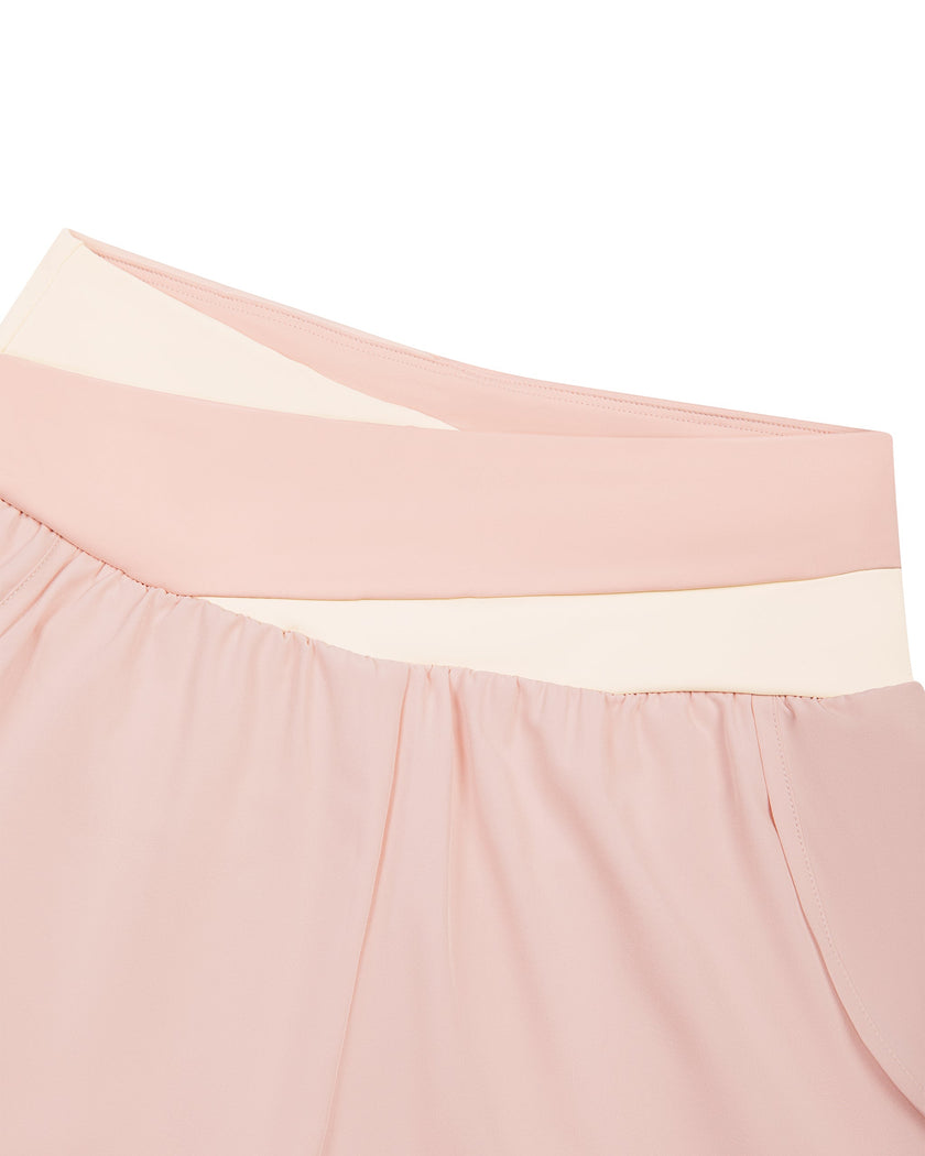 Closeup of crossover light pink and apricot waistband on TrackLine Synergy Layered Leggings