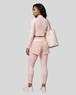 Full body back view of woman wearing TrackLine Synergy Layered Leggings in light pink and apricot