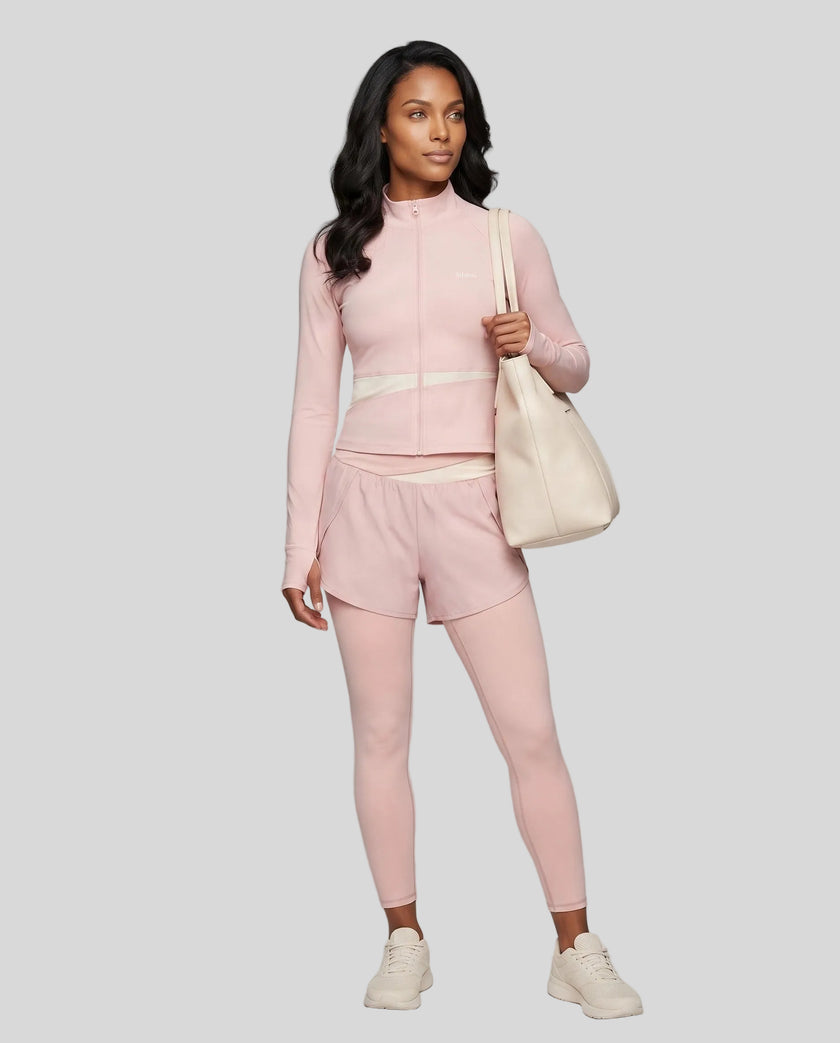 Full body front view of woman wearing TrackLine Synergy Layered Leggings in light pink and apricot