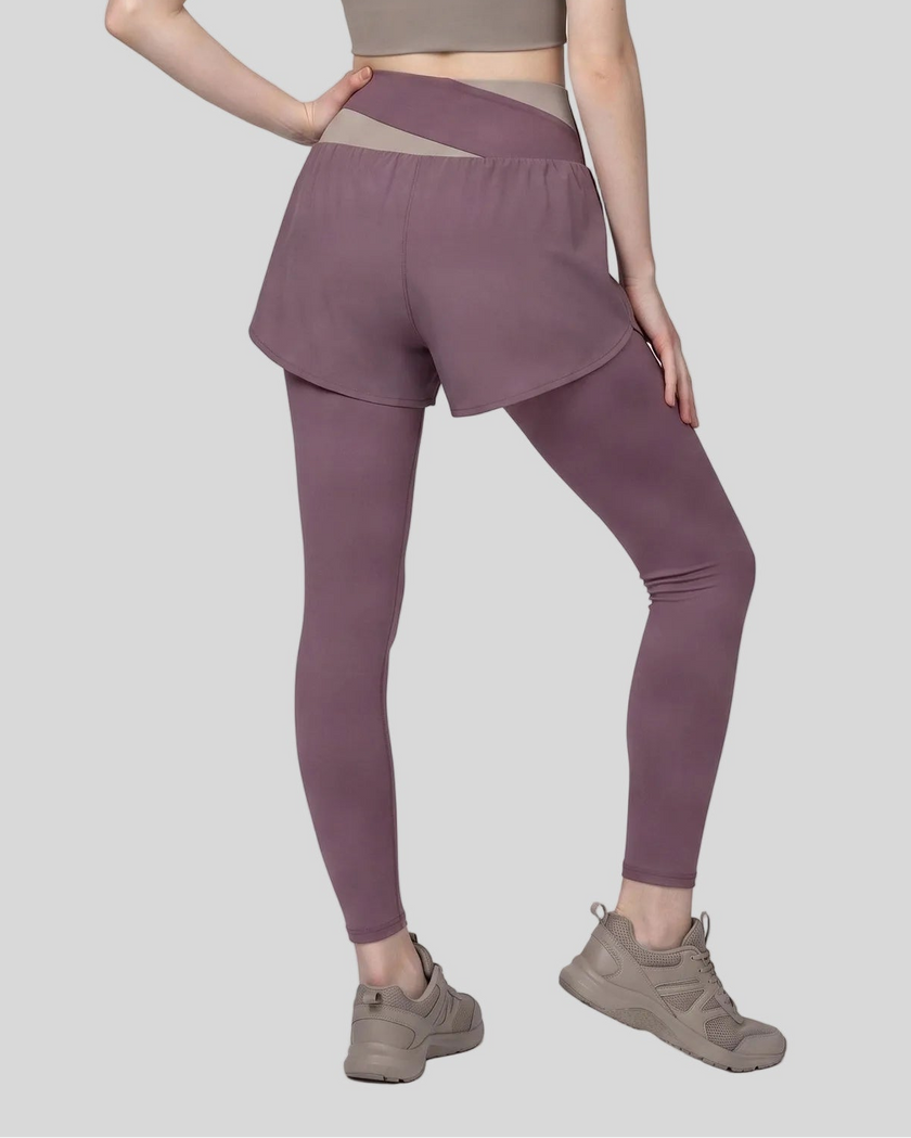 Lower body back view of woman wearing TrackLine Synergy Layered Leggings in misty purple with gray purple crossover waistband