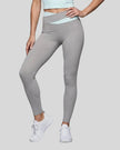 Woman wearing TrackLine Synergy Leggings in Light Gray with Light Blue crossover waistband, lower body front view