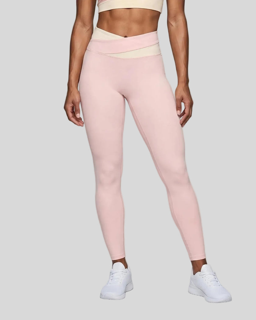 Woman wearing TrackLine Synergy Leggings in Light Pink with Apricot crossover waistband, lower body front view