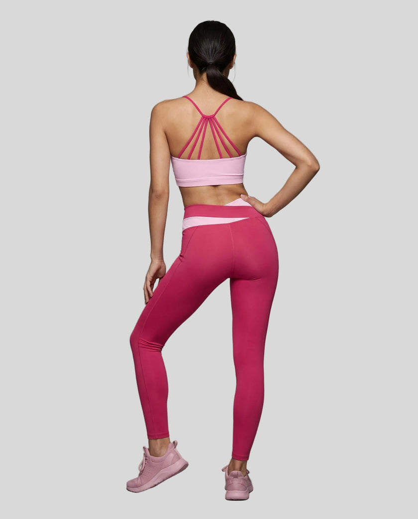 Woman wearing TrackLine Synergy Leggings in Rose Red with Pink crossover waistband, full body back view