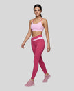Woman wearing TrackLine Synergy Leggings in Rose Red with Pink crossover waistband, full body front view
