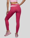 Woman wearing TrackLine Synergy Leggings in Rose Red with Pink crossover waistband, lower body back view