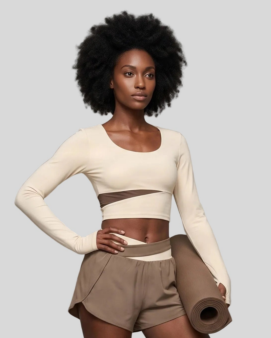 Woman wearing TrackLine Synergy Long Sleeve Top in apricot with khaki asymmetric front detail
