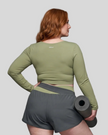 Back view of woman wearing TrackLine Synergy Long Sleeve Top in bean green