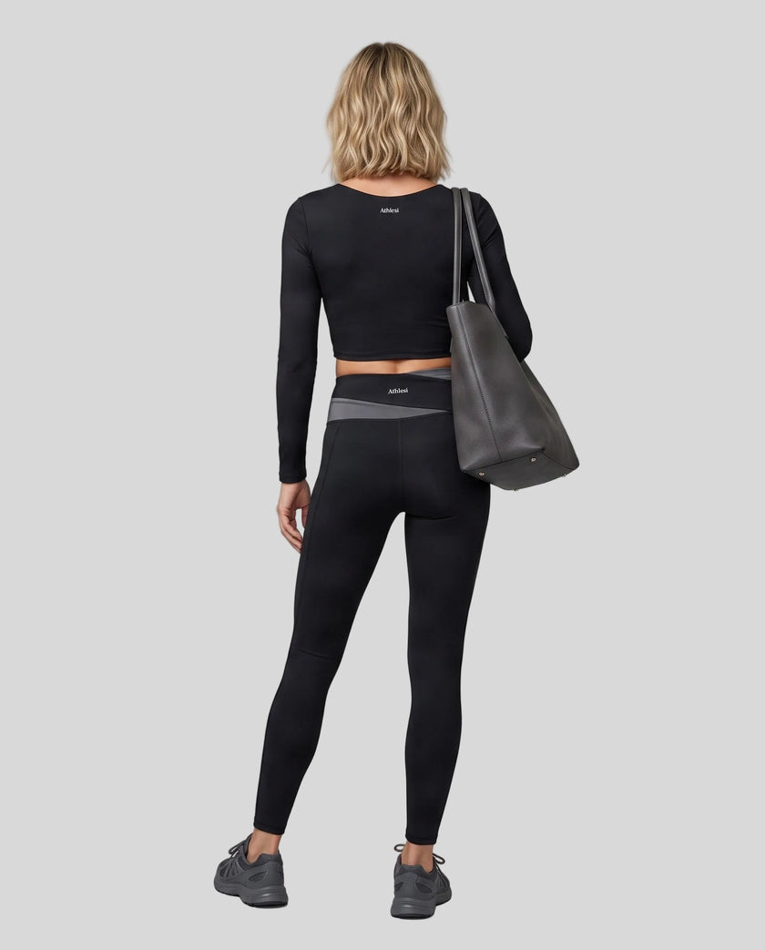 Full body back view of woman wearing TrackLine Synergy Long Sleeve Top in black
