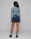 Full body back view of woman wearing TrackLine Synergy Long Sleeve Top in gray blue
