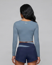 Back view of woman wearing TrackLine Synergy Long Sleeve Top in gray blue